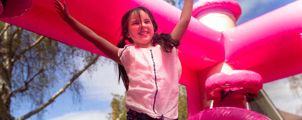 Smiling girl jumping on princess bouncy castle in Victoria, BC
